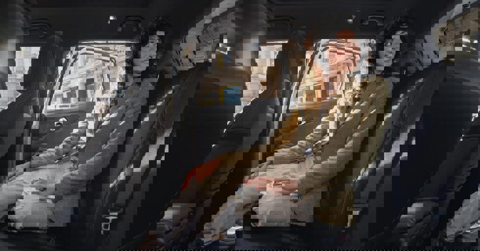 Vrouw die op de achterbank van de BYD ATTO 2 zit.